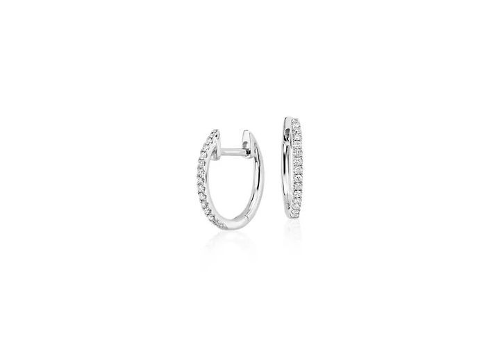 A pair of April birthstone huggie earrings accented with round diamond pavé